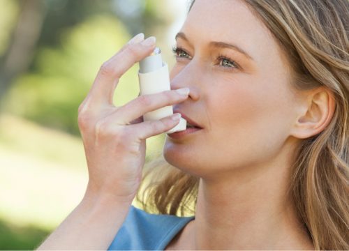 Woman using an inhaler for asthma