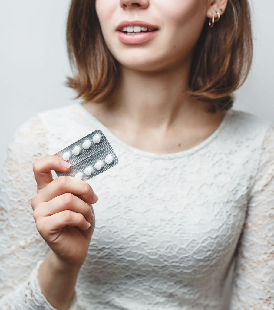 Woman holding birth control pills