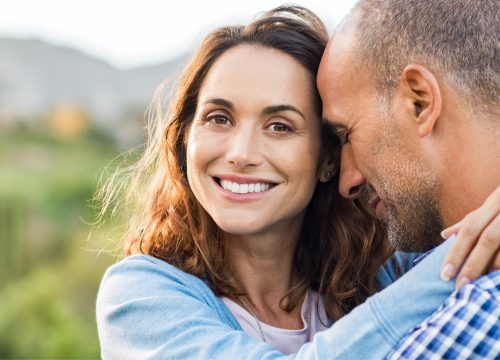 Happy woman after MonaLisa Touch treatments hugging her husband